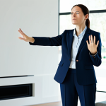 A professional woman in a modest business suit, standing in a sleek, minimalist smart home living room. Her hands are mid-air, performing a slightly awkward and repetitive gesture towards an unseen interface, conveying a sense of frustration and cognitive overload. The scene is well-lit with soft, indirect light, emphasizing her determined yet perplexed expression. fully clothed, appropriate attire, modest clothing, safe for work, appropriate content, professional, family-friendly, perfect anatomy, correct proportions, natural pose, well-formed hands, proper finger count, realistic, high quality, professional photography.